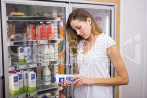 Pretty woman looking at bottle of milk
