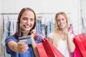 Happy friends handing a credit card