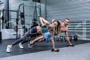 Muscular couple doing plank exercise together