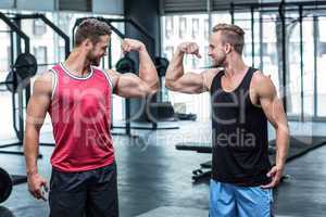 Two smiling muscular men flexing biceps