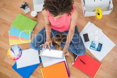 Young creative businesswoman scrolling on tablet