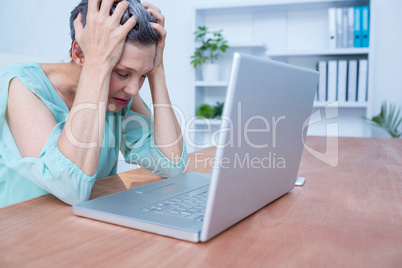 Troubled businesswoman frowning on her laptop