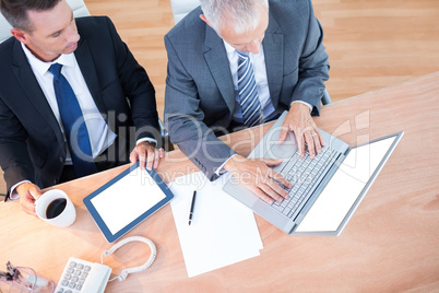 High view of businessmen working together on laptop