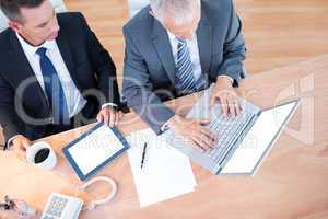 High view of businessmen working together on laptop