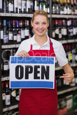 Portrait of a smiling blonde woman showing a sign