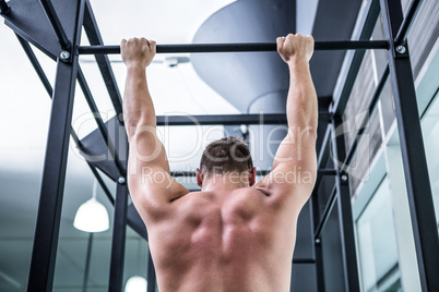 Back view of muscular man doing pull ups