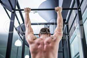 Back view of muscular man doing pull ups