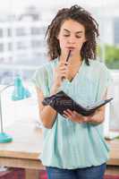 Thoughtful businesswoman holding a notebook