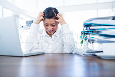Businesswoman getting stressed at her desk