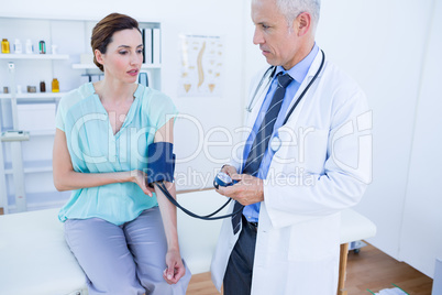 Doctor checking blood pressure of a young woman Doctor checking blood pressure of a young woman