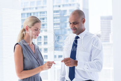 Businessman giving small paper sheet to his colleague