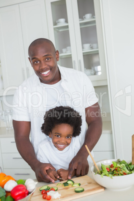 Portrait of happy father and son preparing vegetables