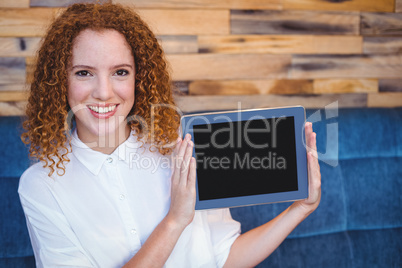 Pretty girl presenting a small tablet at table