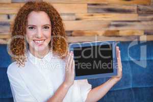 Pretty girl presenting a small tablet at table