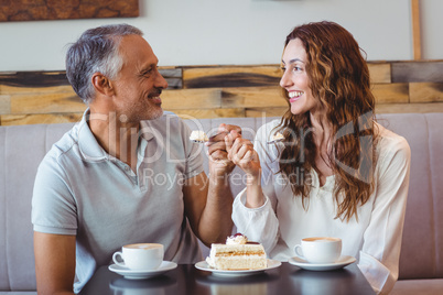 Casual couple having coffee and cake together