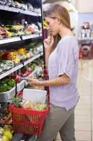 Smiling woman taking a vegetables in the aisle