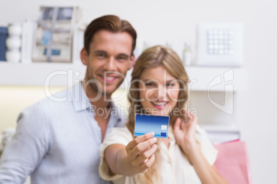 Portrait of a happy couple showing their new credit card