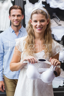 Pretty smiling woman holding bras