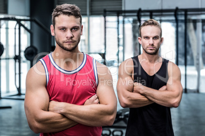 Two serious muscular men with arms crossed