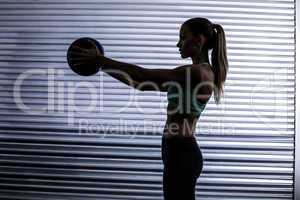 Muscular woman doing ball exercise