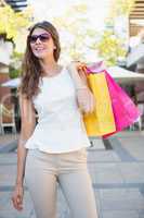 Smiling woman with shopping bags wearing sunglasses