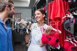 Young happy woman showing clothes to her husband