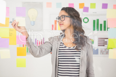 Pretty designer looking at post its on window