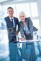 Business people looking at camera behind desk