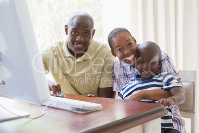 Portrait of happy smiling family using computer