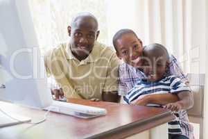 Portrait of happy smiling family using computer