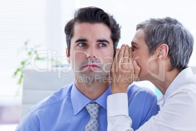 Two business people looking at a paper while working on folder