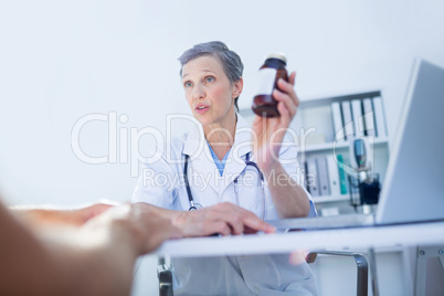 Female doctor holding a box of pills