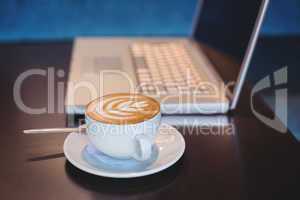 Close-up of laptop and coffee on table