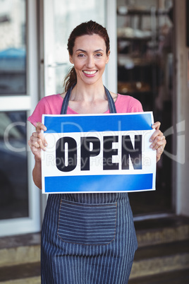 Pretty worker showing open sign