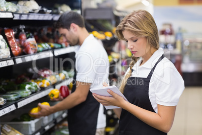 A serious staff woman writing on notepad