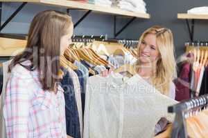 Pretty blonde woman showing clothes to her friend