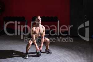 Muscular man lifting a kettlebell