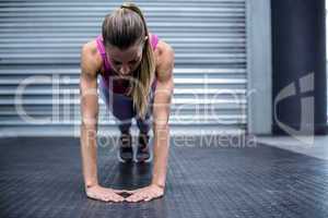 Muscular woman doing press up exercises