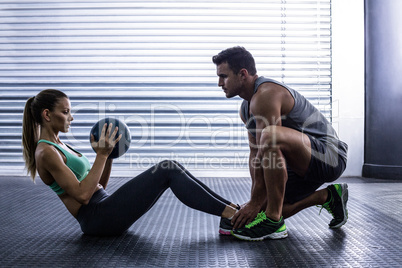 Muscular couple doing abdominal ball exercise