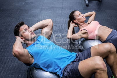 Muscular couple doing abdominal crunch