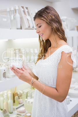 Smiling woman testing moisturizer