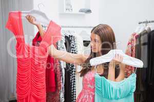 Woman having difficulties choosing dress