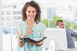 Smiling businesswoman writing on a notebook