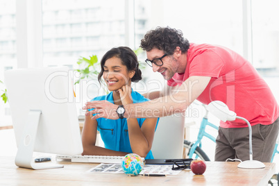 Cheerful colleagues using computer