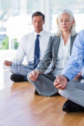 Business people doing yoga on floor
