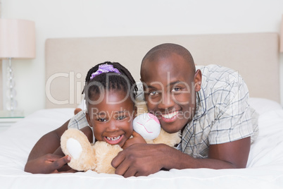 Pretty little girl with his father in bed