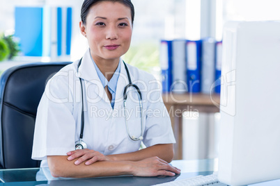 Confident doctor looking at camera with arms crossed