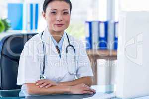Confident doctor looking at camera with arms crossed