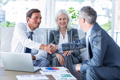 Business people shake hands on couch