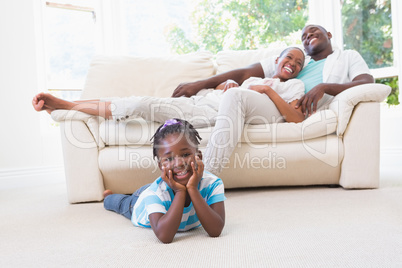 Portrait of a pretty couple sitting on couch and their  daughter